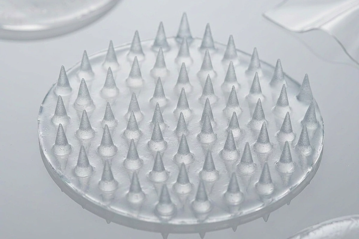 Close-up of dissolving microcone projections arranged on a translucent microneedle pimple patch